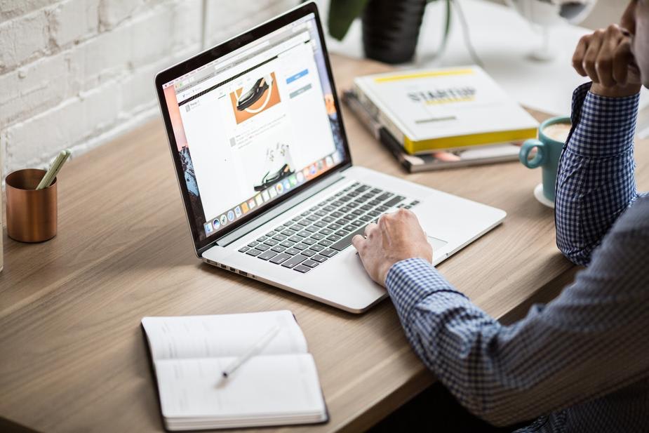 man works at an open laptop on a desk